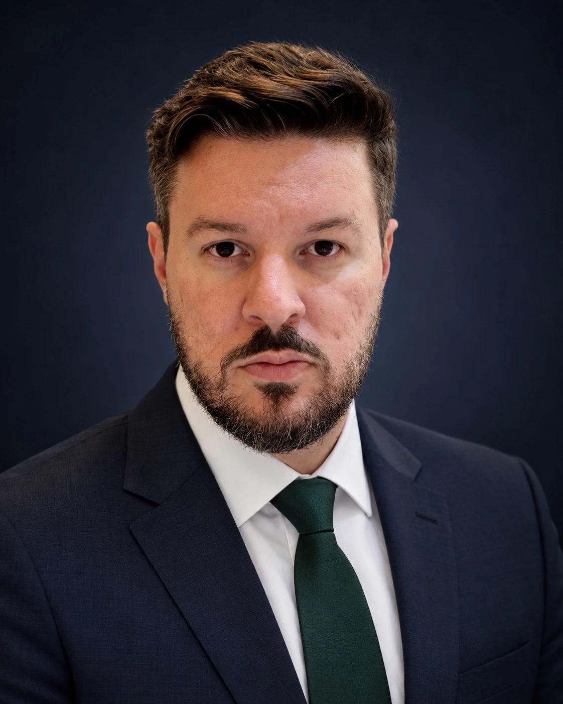 Dr. Rafael William de Souza usando terno azul-marinho e gravata verde